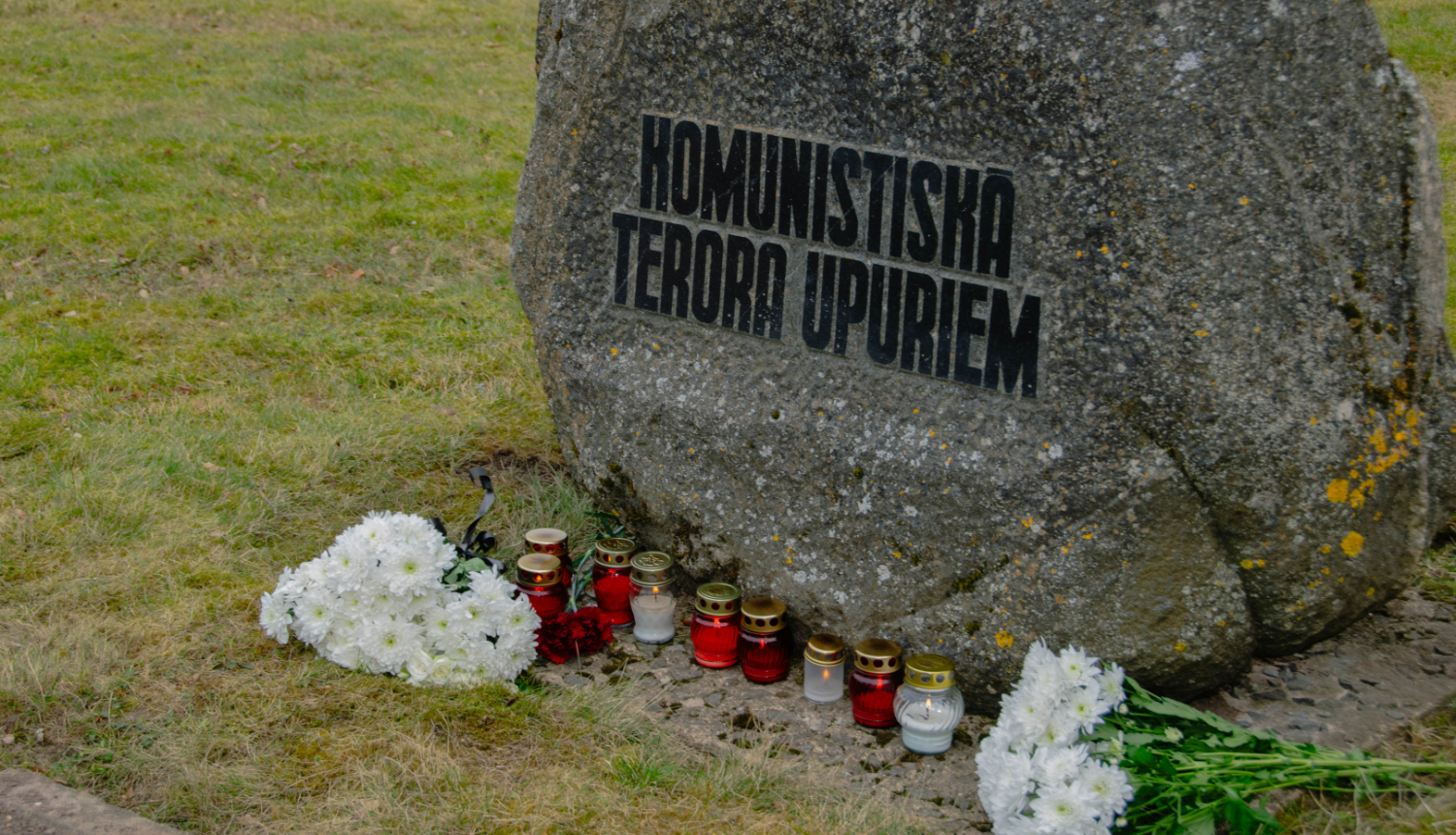 Piemiņas akmens ar ziediem Komunistiskā terora upuriem
