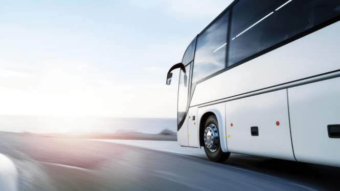 Autobuss brauc pa ceļu, izplūdis fons