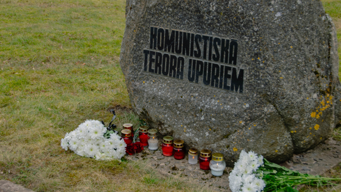 Piemiņas akmens ar ziediem Komunistiskā terora upuriem