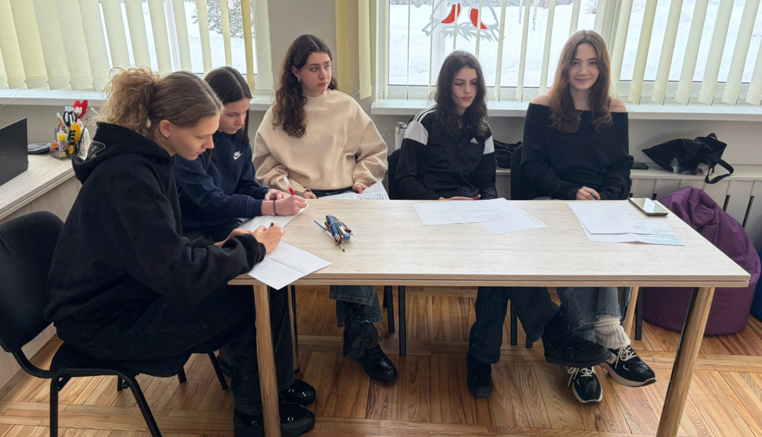 Pie galda sēž jaunieši: 5 meitenes